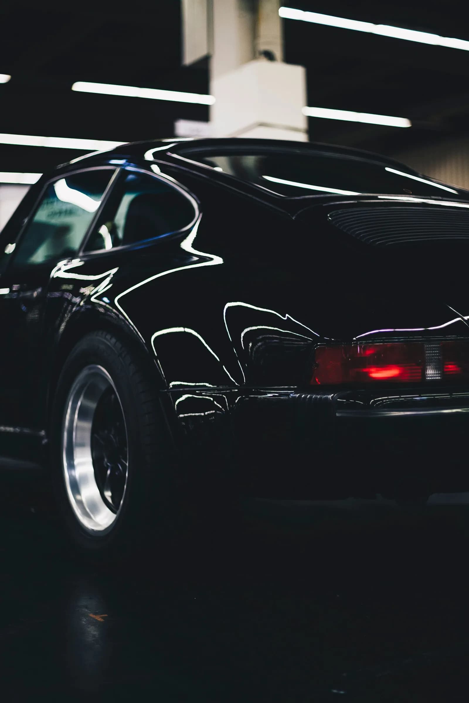 Remise de la clé d'une Porsche — détail de carrosserie sous une lumière chaude