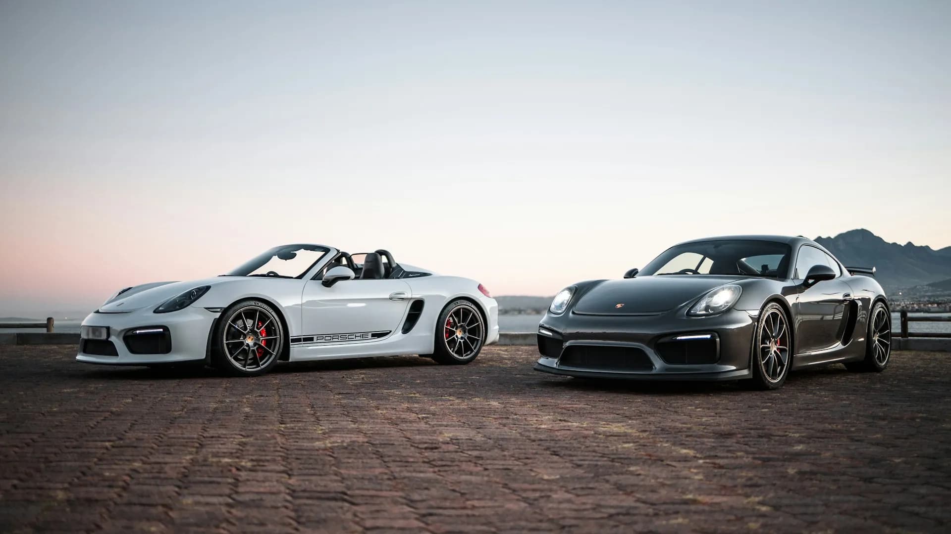 Boxster blanc de trois quarts avant sur les pavés au crépuscule