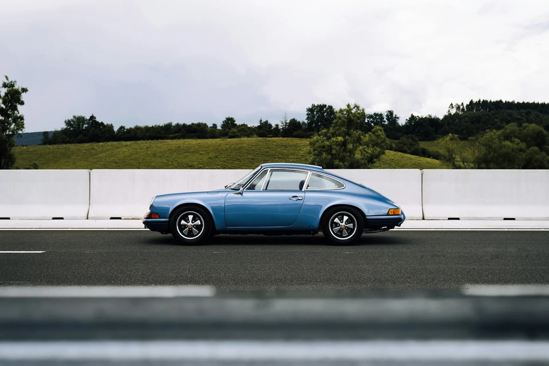 911 classique bleue de profil sur une voie dégagée