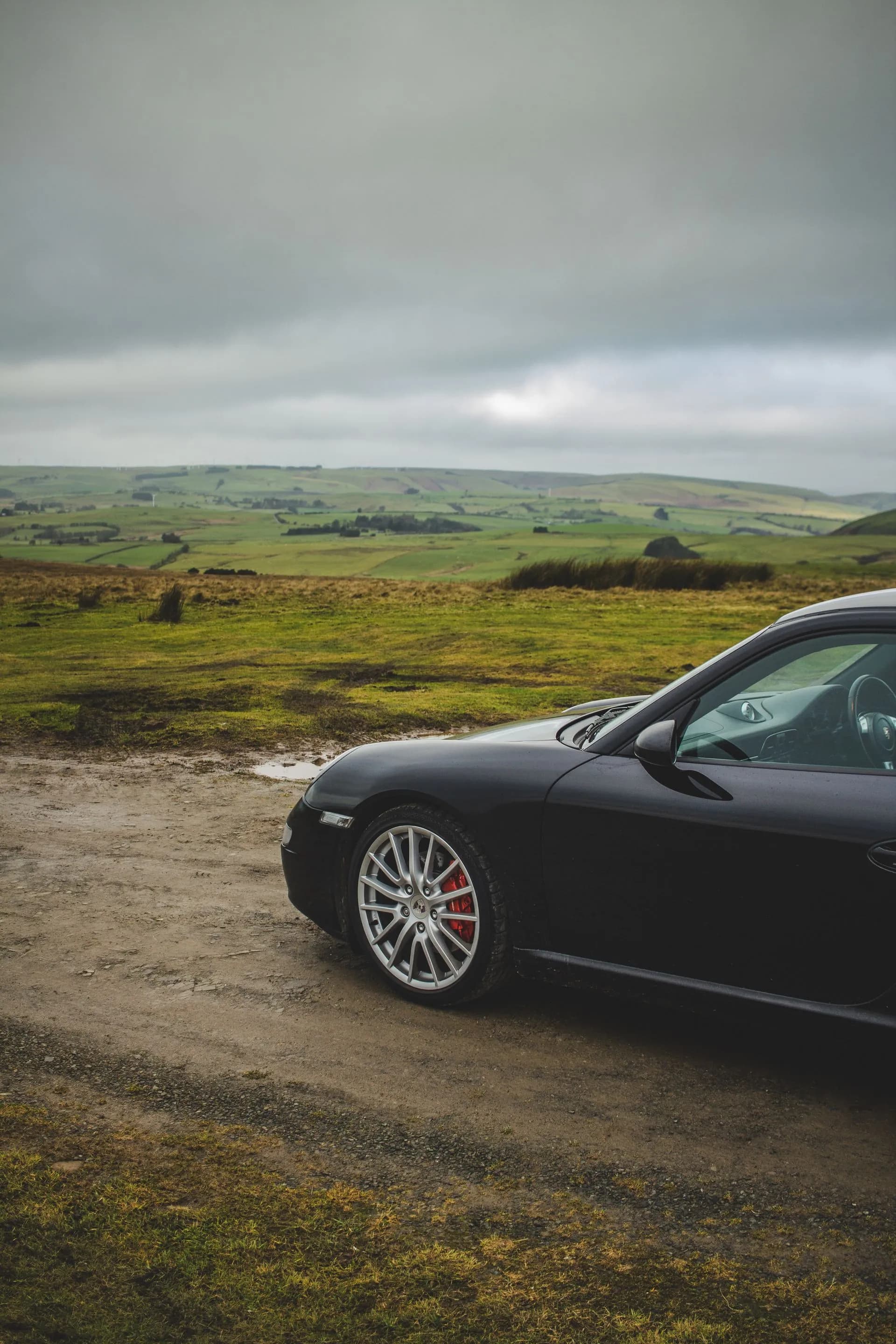 997 Carrera S gris foncé de trois quarts avant sur un chemin de campagne