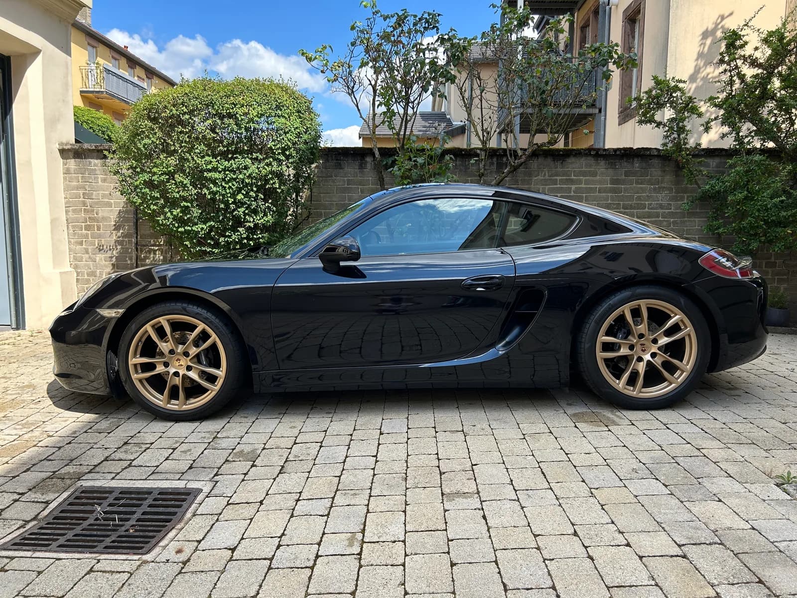 Porsche Boxster noire de profil, jantes bronze