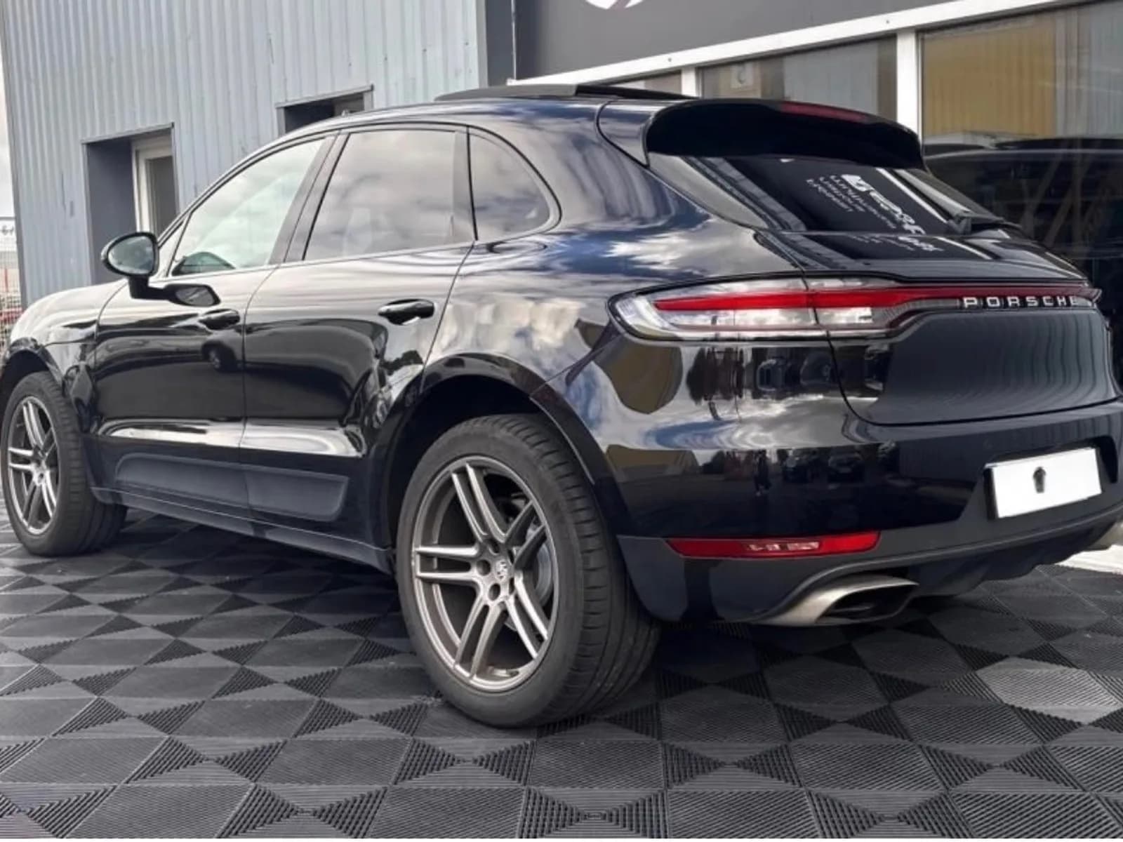 Porsche Macan noir de trois quarts arrière dans le showroom